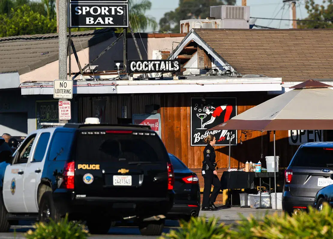 A police car parked in front of a sports bar enforcing alcohol regulations.
